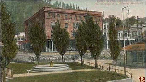 Old picture of Dunsmuir Fountain in foreground and Weed Hotel in background hill with trees behind hotel