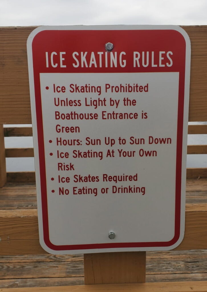 Sign outlining ice skating rules: skating allowed only with green light, hours from sunrise to sunset, skates required, no food/drink.