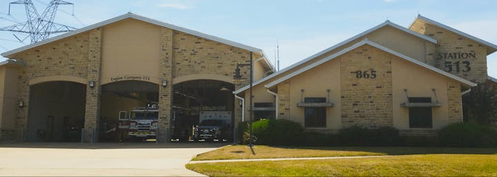 A fire station with trucks inside and "Engine Company 513" signage on the building.