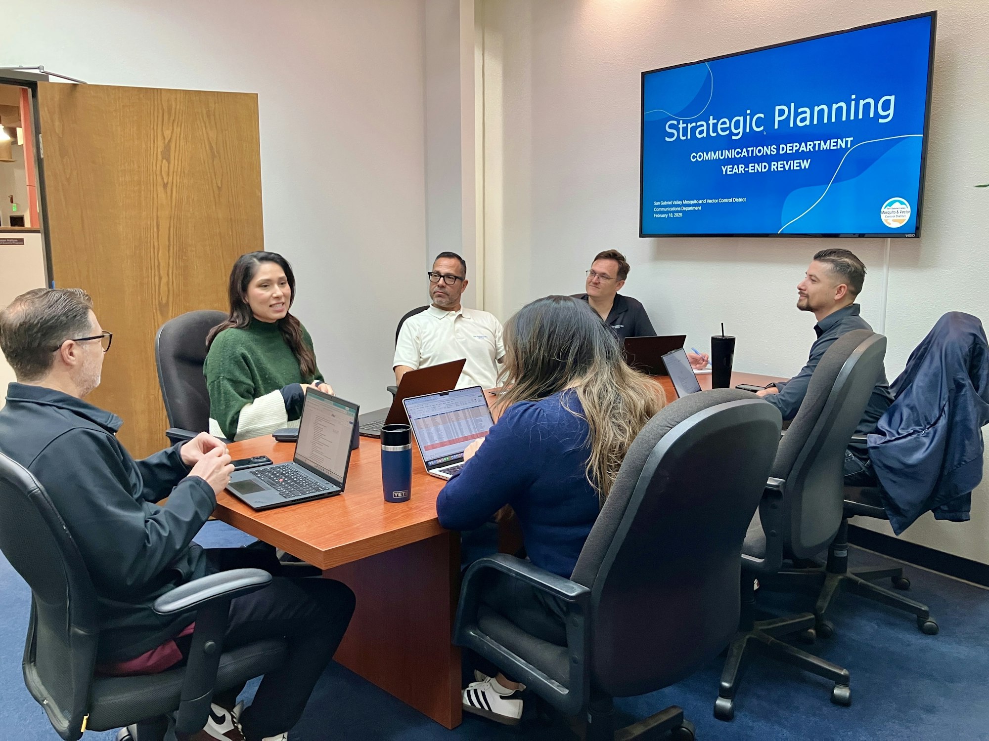 A meeting in a conference room focused on strategic planning and year-end review for a communications department.