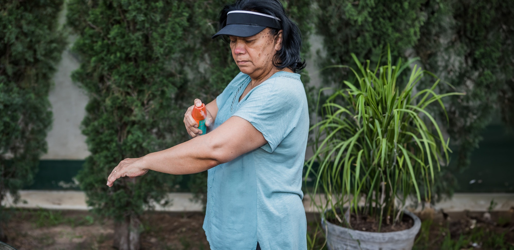 Woman applies mosquito repellent.