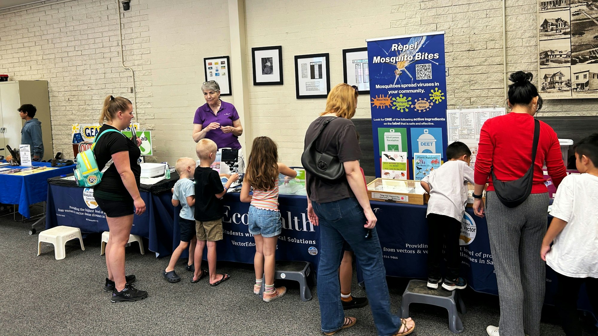 People at an informational booth about mosquito bite prevention.