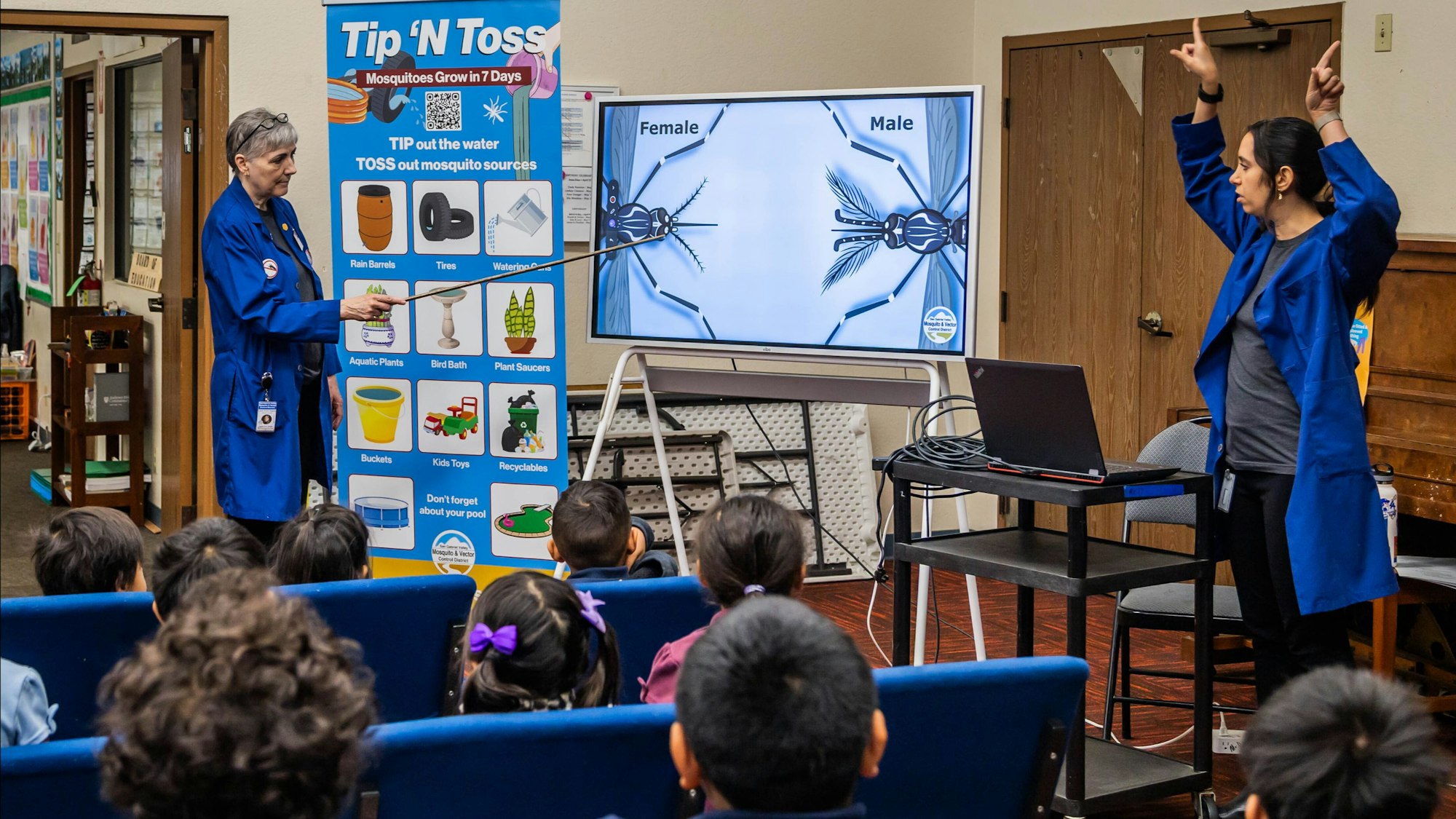 A presentation about mosquito prevention is happening, with educators showing tips to eliminate standing water to kids.