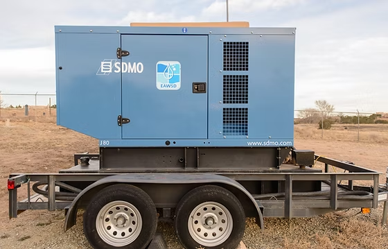 A blue SDMO generator mounted on a trailer in an outdoor setting.