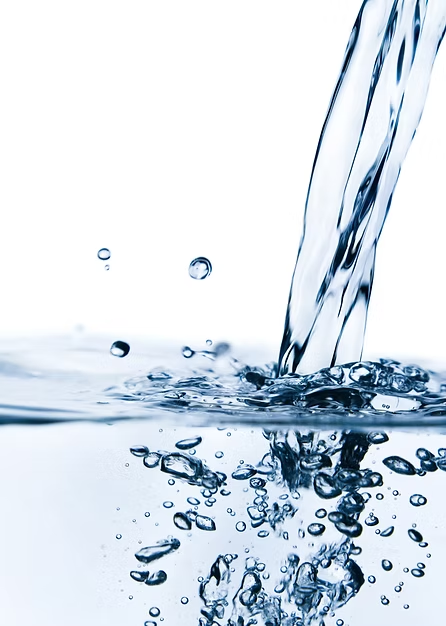 A stream of water pouring into a clear surface, creating bubbles and splashes.