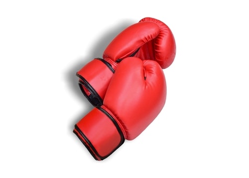 A pair of red boxing gloves, designed for training or competition in the sport of boxing.