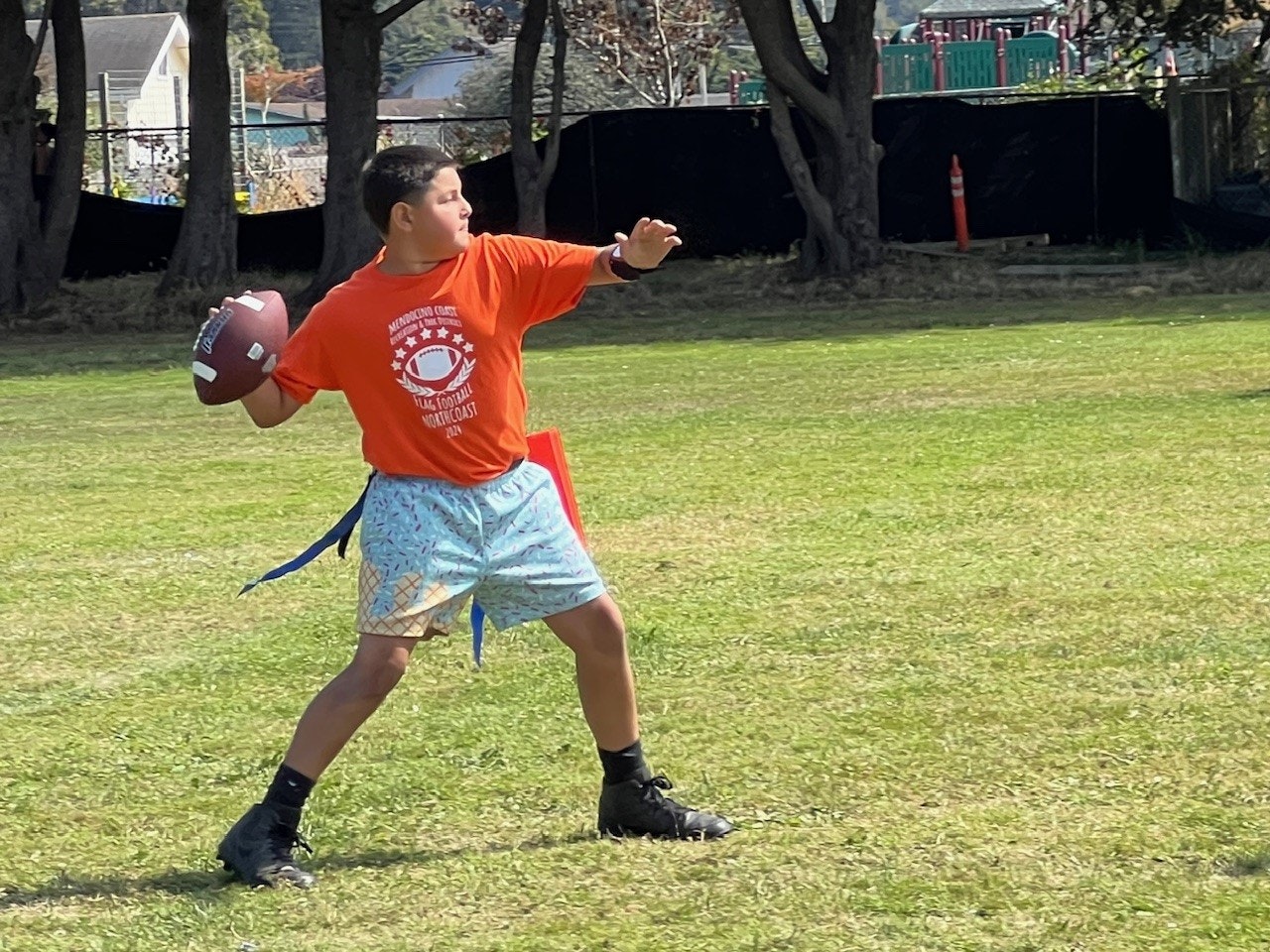 A person throwing a football in a park.