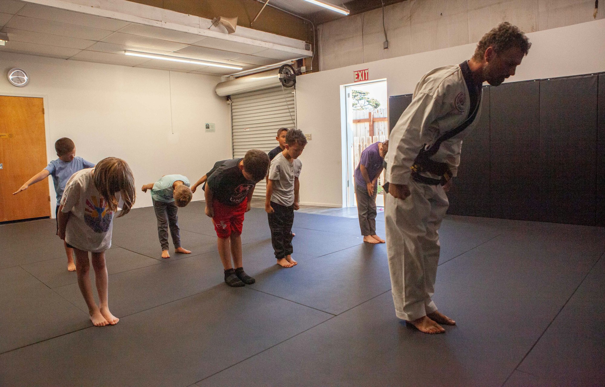 Children in a martial arts class, bowing to an instructor.