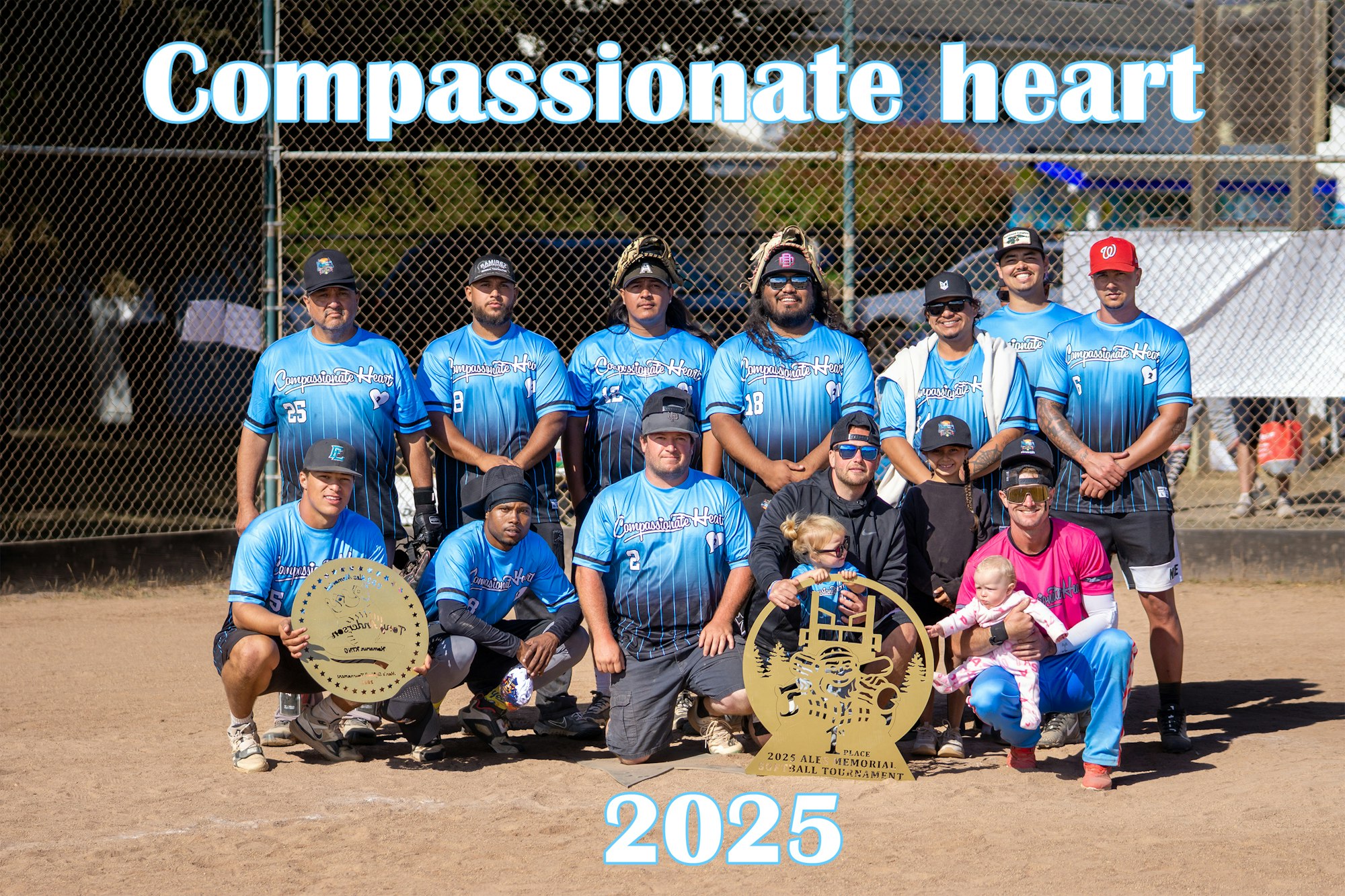 A baseball team poses with awards, wearing blue "Compassionate Heart" jerseys, with "2025" written above.