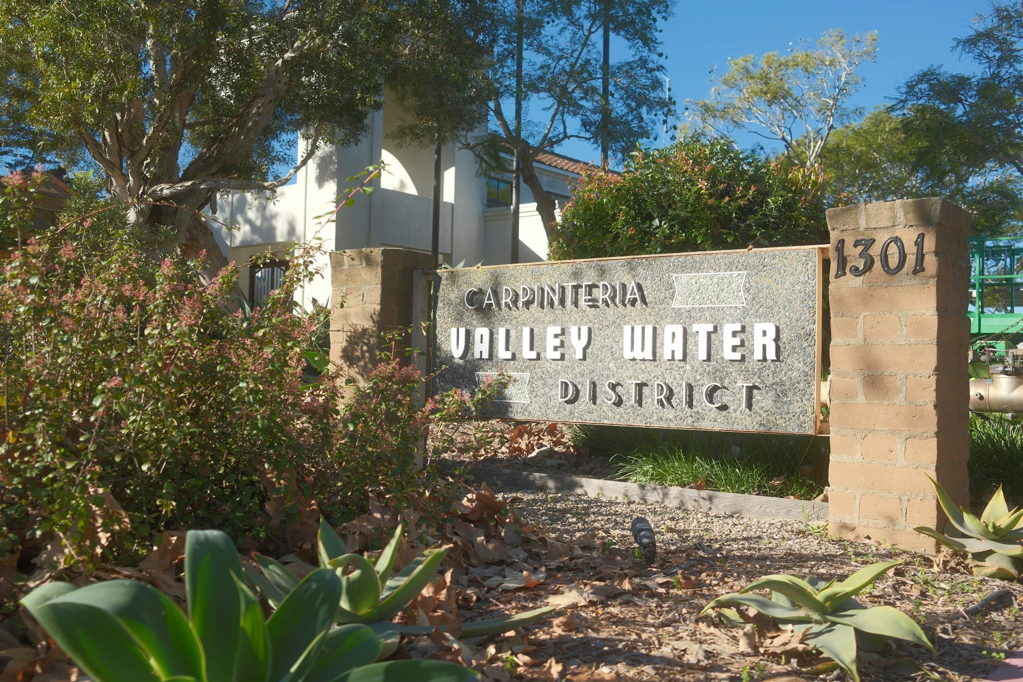 A stone sign for the Carpinteria Valley Water District, with landscaping and building visible in the background.