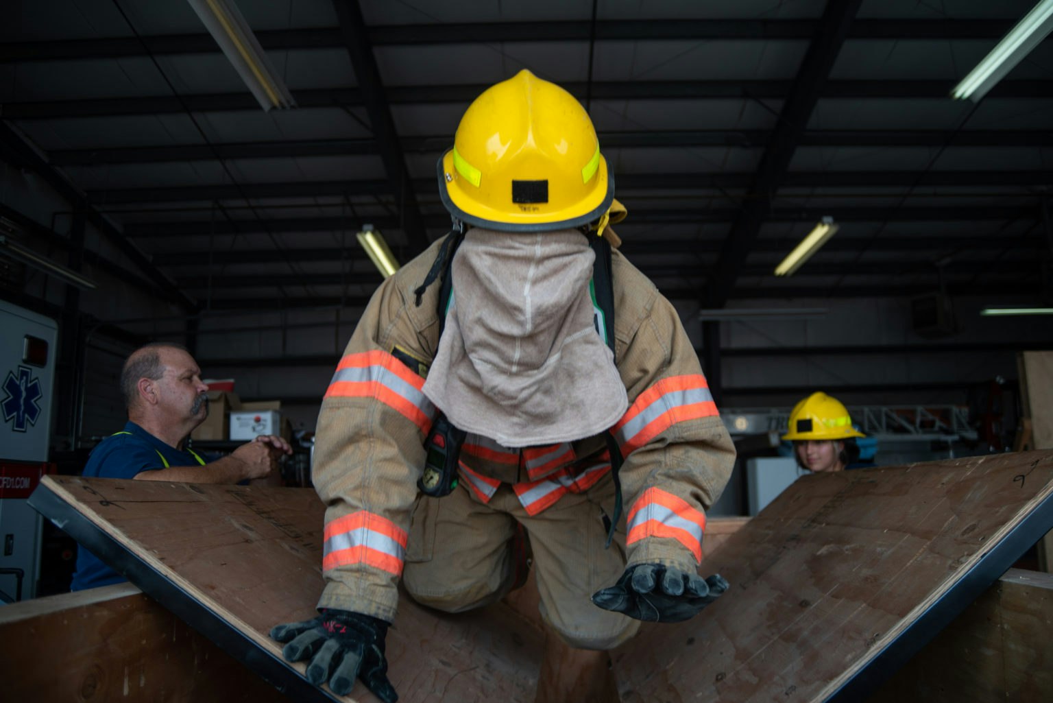 May contain: clothing, hardhat, helmet, person, worker, plywood, wood, adult, male, man, face, and head