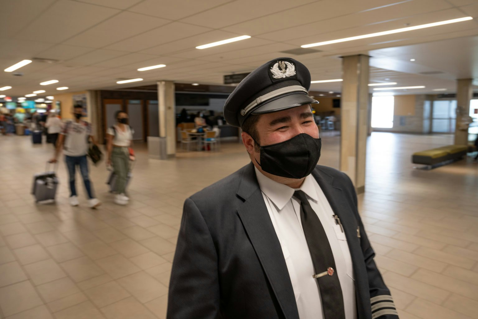 May contain: captain, officer, person, adult, male, man, accessories, formal wear, tie, clothing, suit, guard, airport, terminal, jeans, and pants