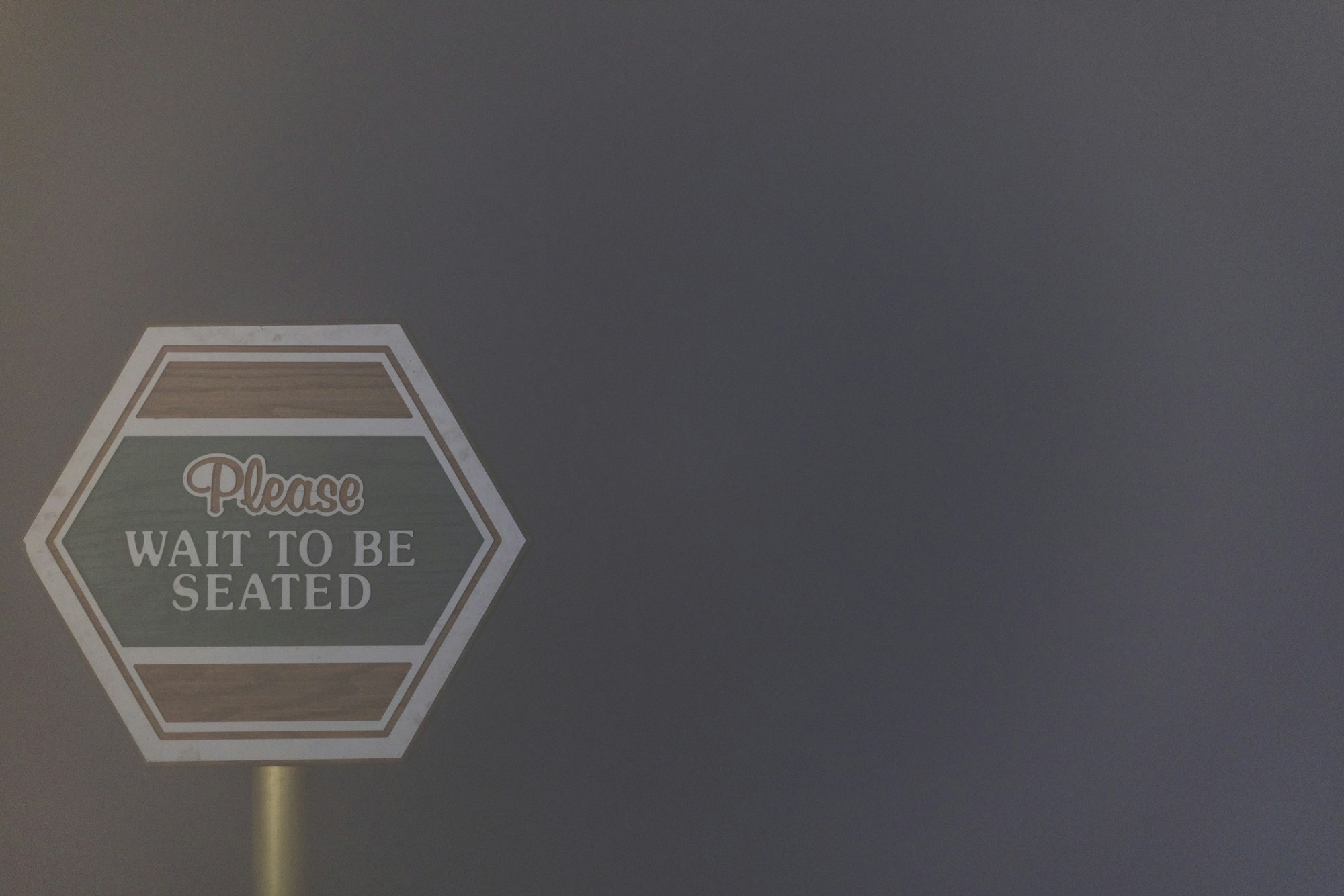 Hexagonal sign: "Please wait to be seated."