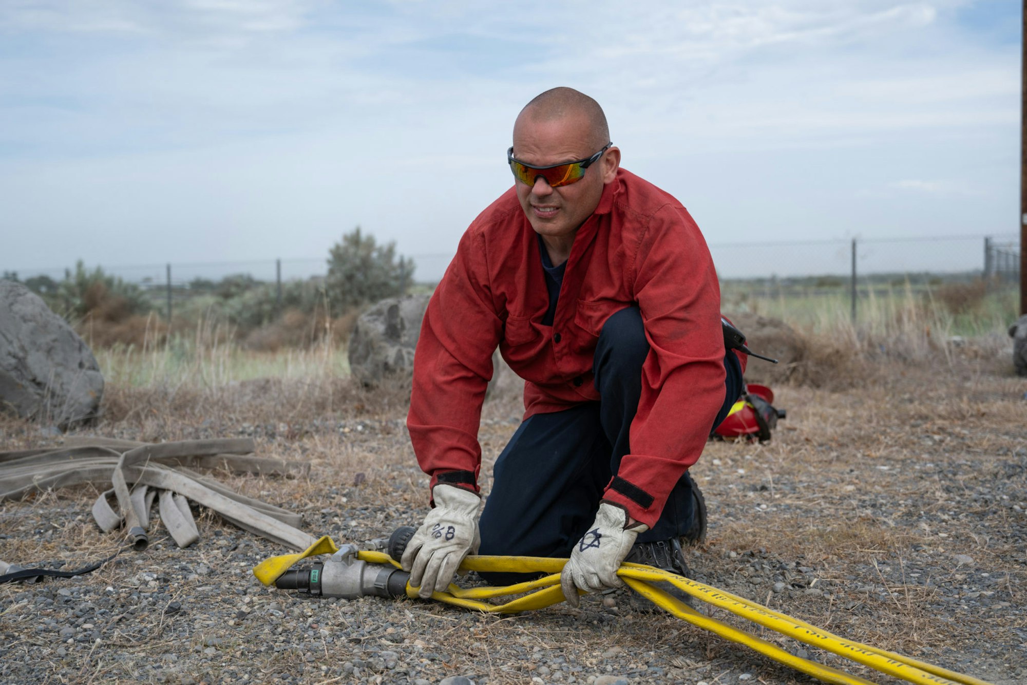 May contain: accessories, sunglasses, person, worker, clothing, glove, gravel, road, adult, male, and man