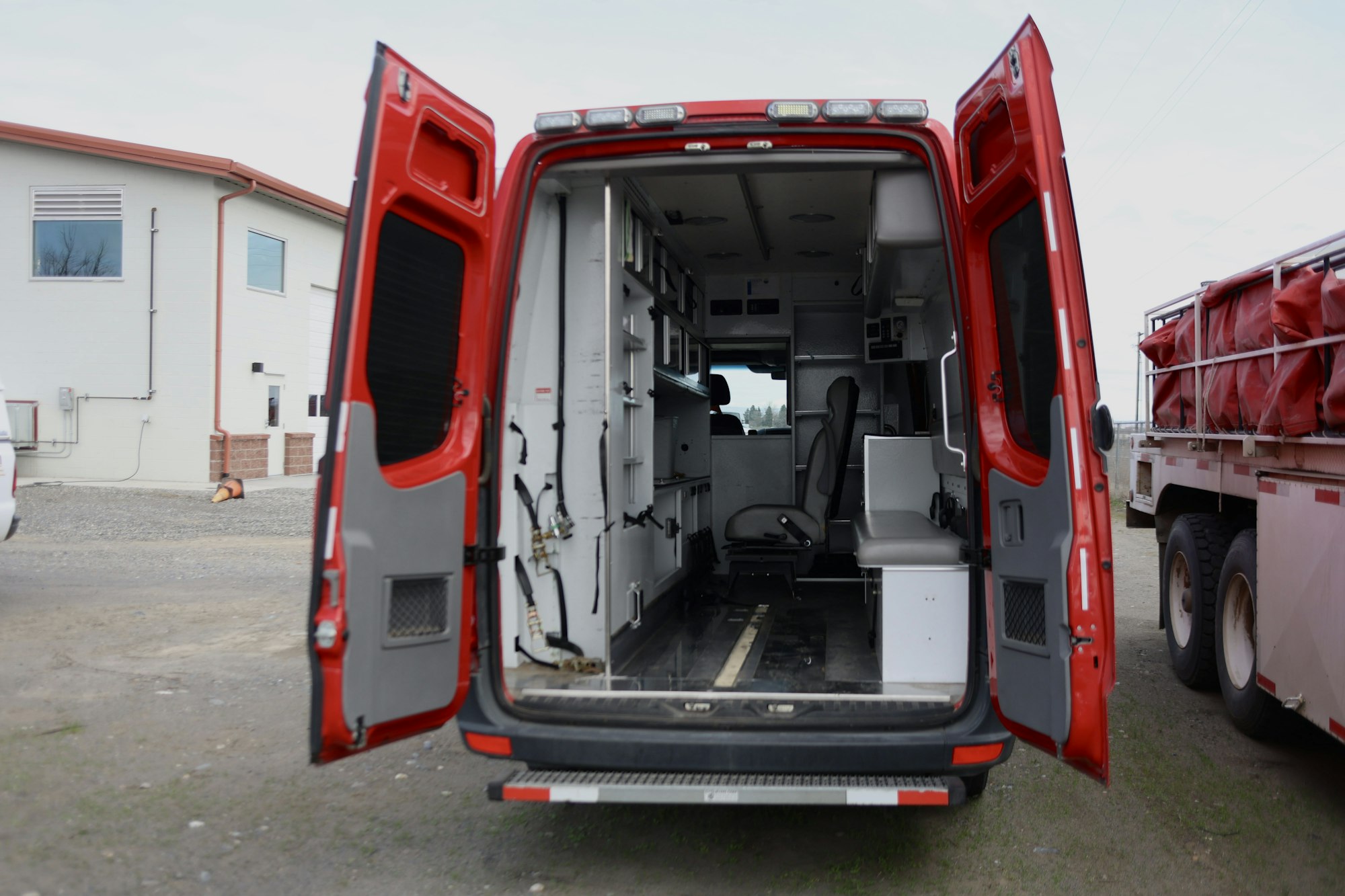 An open red ambulance van with interior seats and equipment visible.