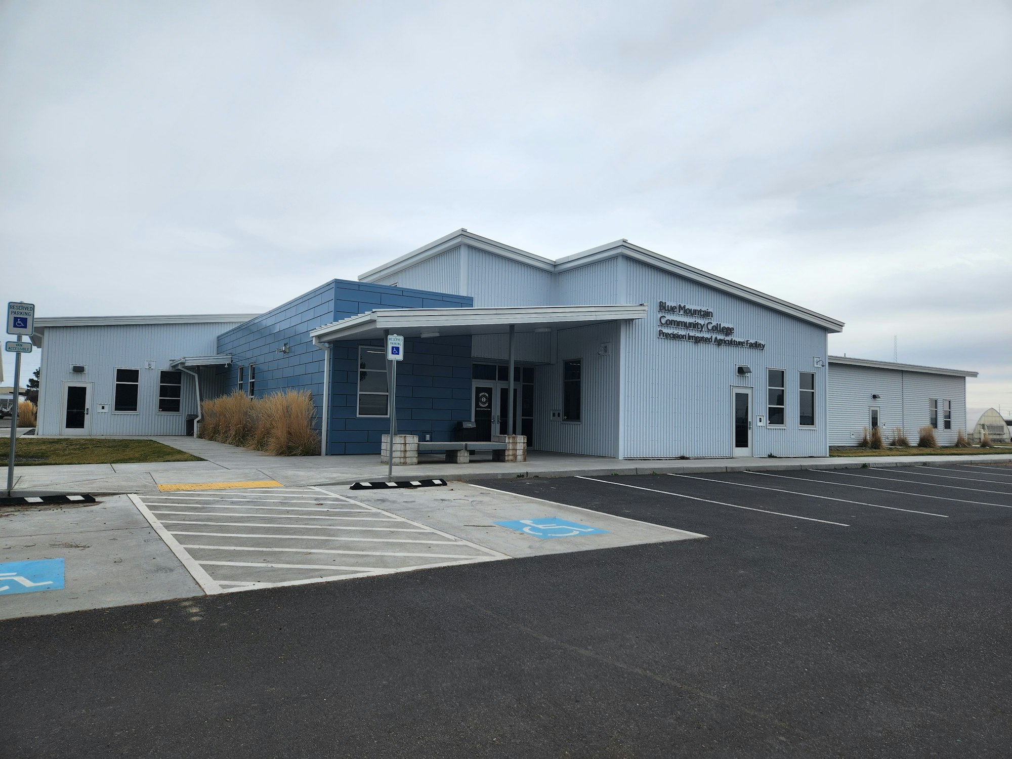 Single-story building labeled "Blue Mountain Community College" with a parking lot and accessible spaces.