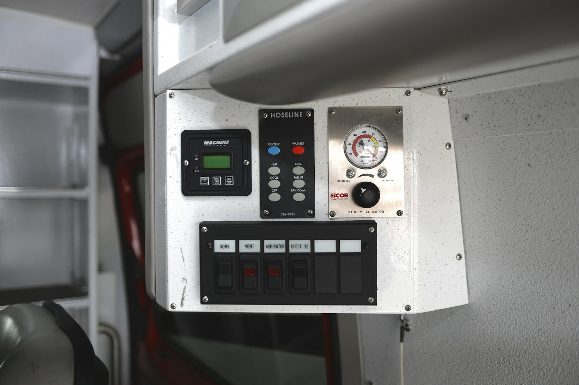 A control panel with switches, gauges, and vacuum regulator, labeled "Hoseline" and "SSCOR."