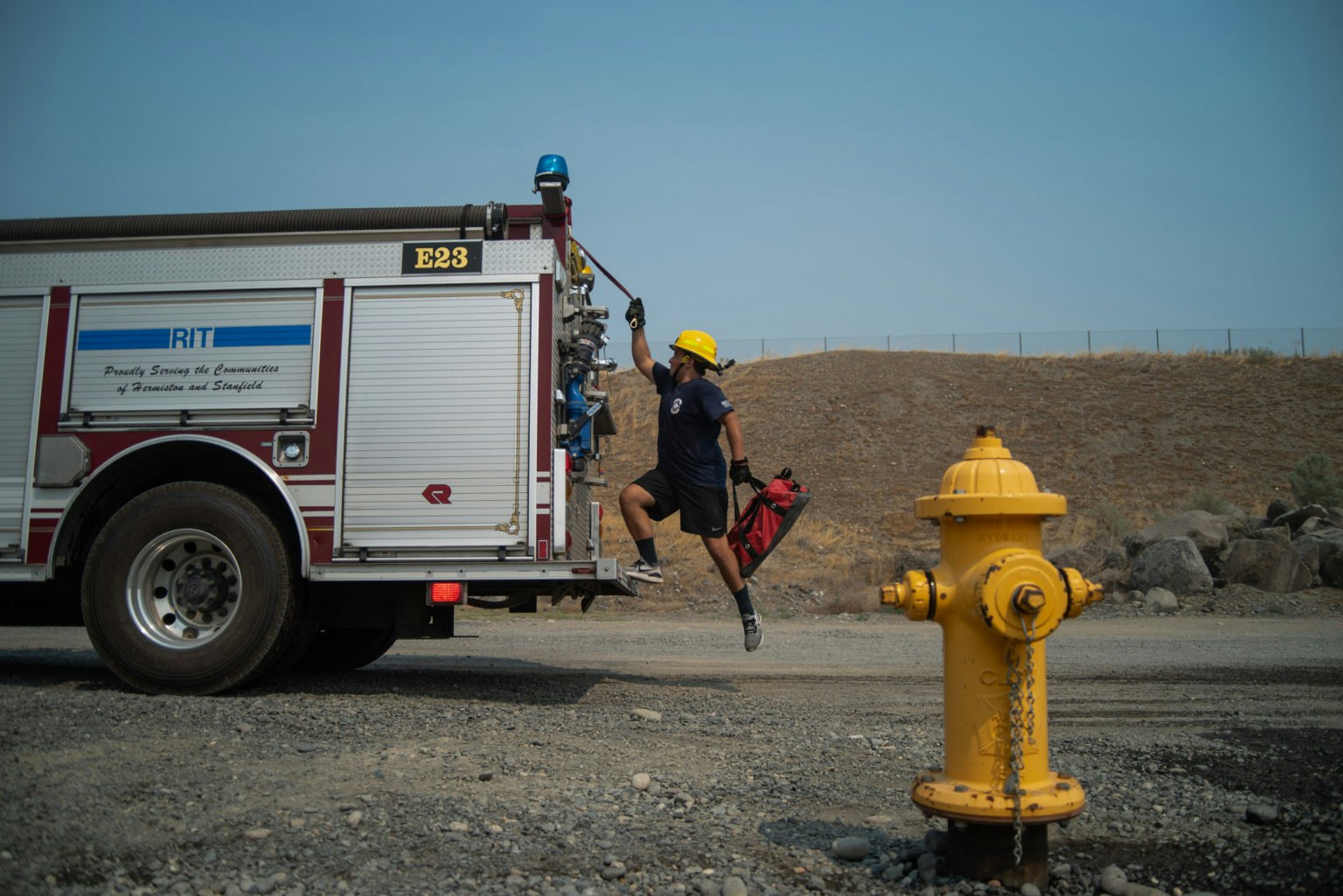 May contain: person, worker, clothing, hardhat, helmet, machine, wheel, glove, fire hydrant, hydrant, transportation, truck, and vehicle