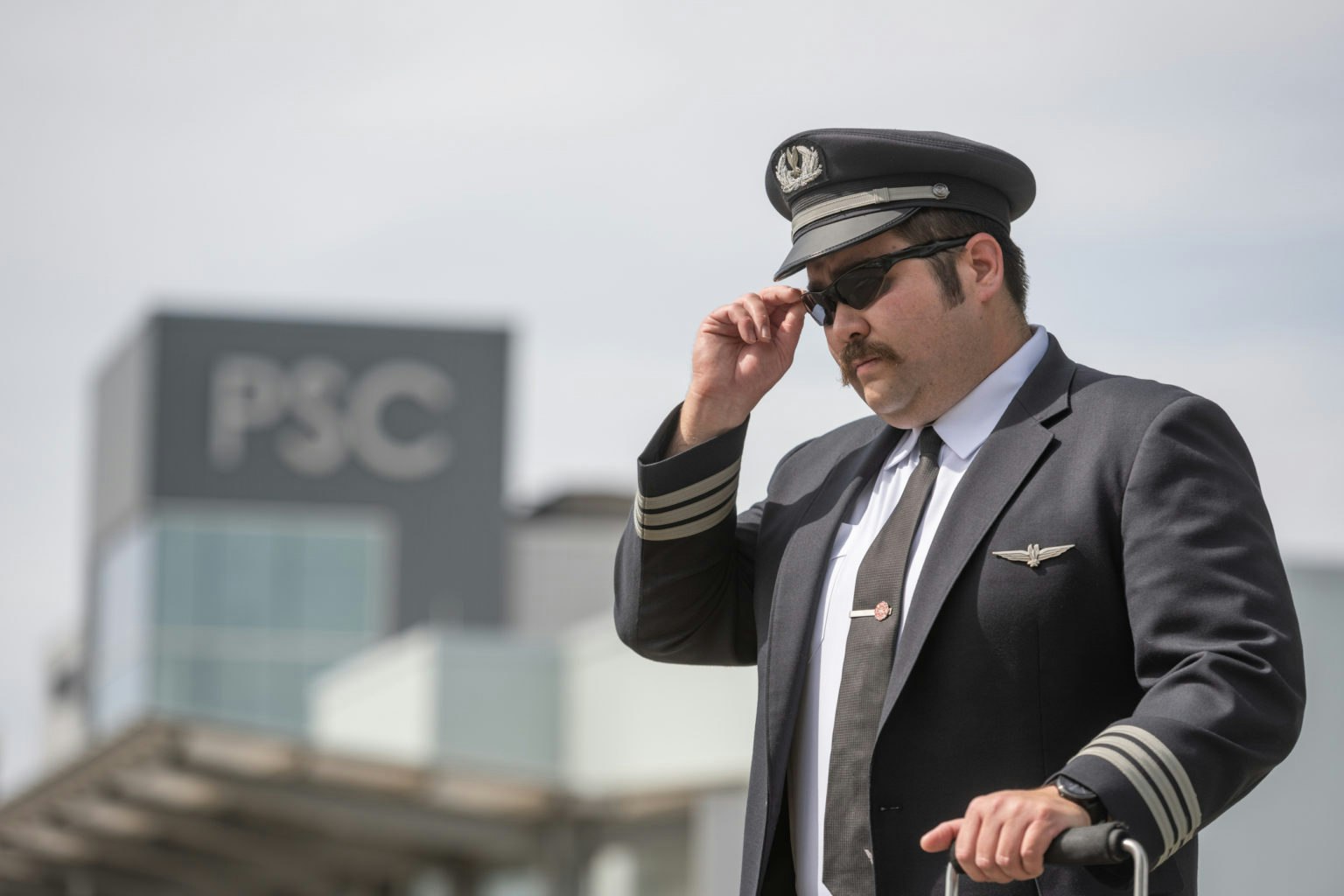 May contain: captain, officer, person, adult, male, man, accessories, sunglasses, formal wear, tie, face, head, clothing, and hat