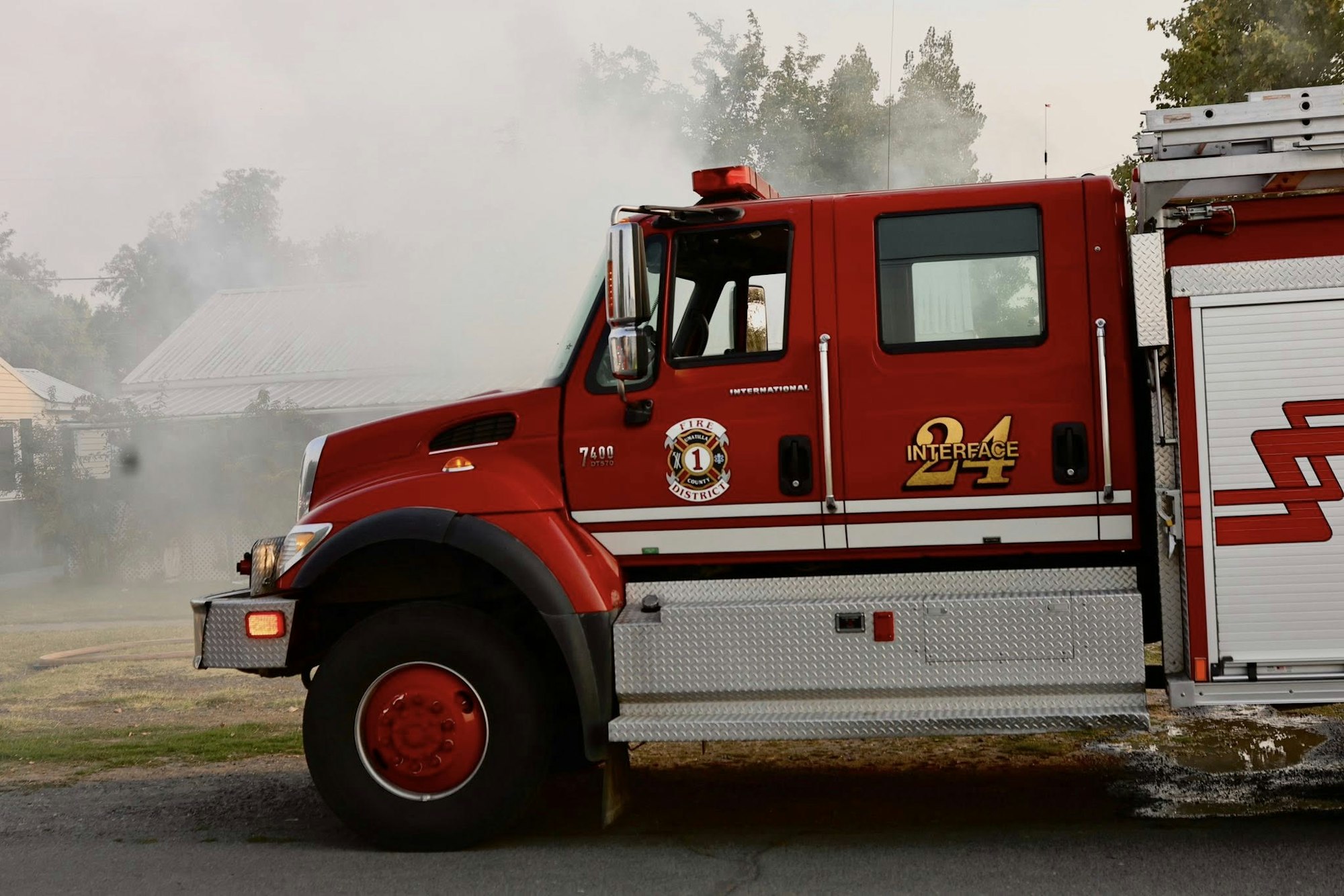 Red fire truck with "Interface 24" on the side, and smoke billowing in the background.