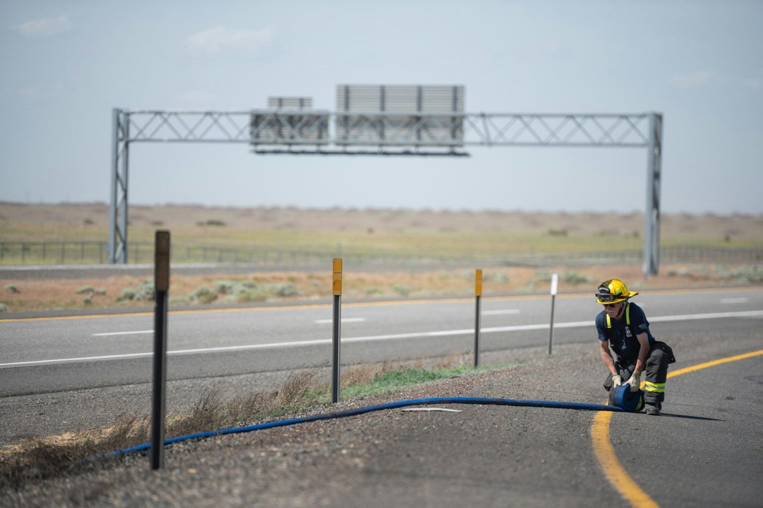 May contain: road, person, tarmac, helmet, clothing, and hardhat