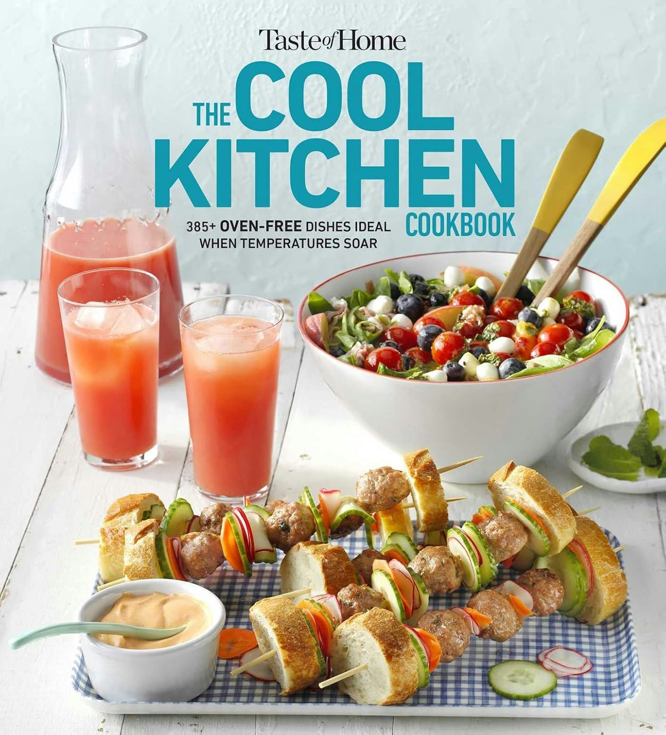 A cookbook cover featuring drinks, salad, skewers, and a dipping sauce with vibrant colors and fresh ingredients.