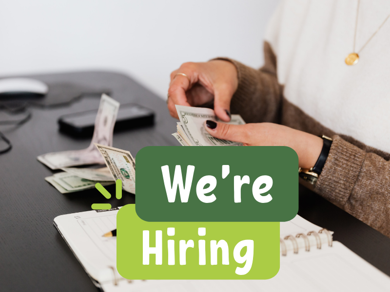 A person is counting cash at a desk while a message reads, "We're Hiring," indicating a job opportunity.