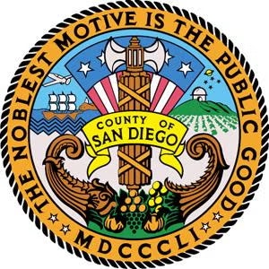 Seal of San Diego County with motto "The Noblest Motive is the Public Good," featuring symbols like agriculture and maritime elements.