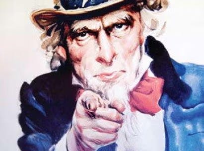 A man in a blue jacket, white hair, and hat pointing forward.