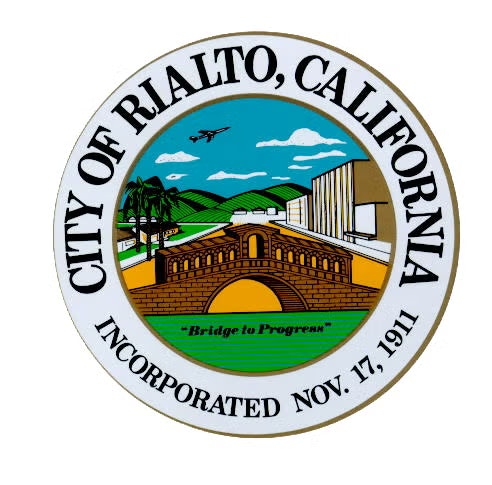 Seal of Rialto, California, featuring a bridge, plane, palm trees, buildings, and "Bridge to Progress" with incorporation date Nov. 17, 1911.