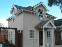 A small, two-story house with a gabled roof and multiple windows.