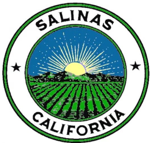 Seal of Salinas, California, featuring a sun rising over fields and hills, framed with stars.