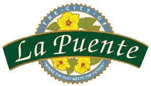 Seal of La Puente city with yellow flowers and green banner stating "La Puente," motto: "Where the Past Meets the Future."