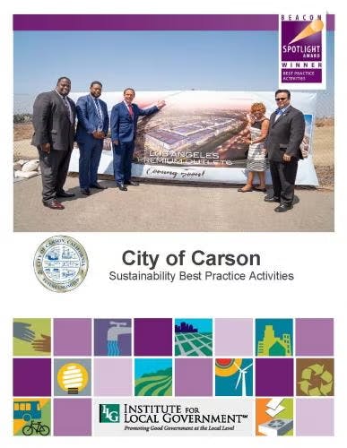 A group of people stand in front of a banner with "City of Carson" and sustainability awards.