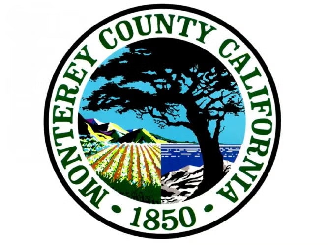 Seal of Monterey County, California, featuring a tree, farmland, mountains, and ocean, with "1850" at the bottom.