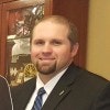 A man in a suit smiling for the camera.