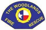 A badge-shaped emblem with text "The Woodlands Fire · Rescue" and a Texas state symbol in the center.
