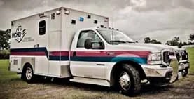 An ambulance parked on a grassy area.