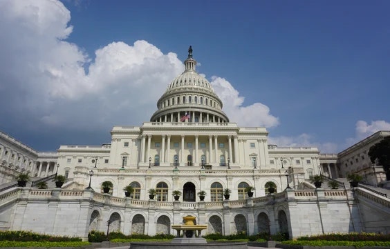 The United States Capitol Building under a partly cloudy sky.