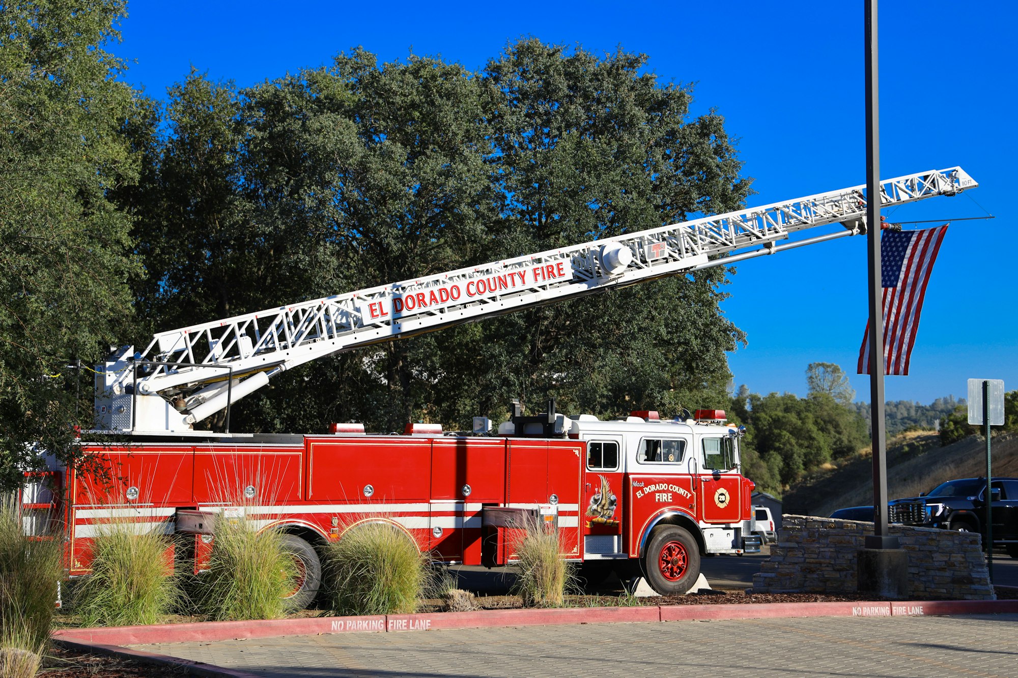 May contain: flag, fire truck, transportation, truck, vehicle, person, and car