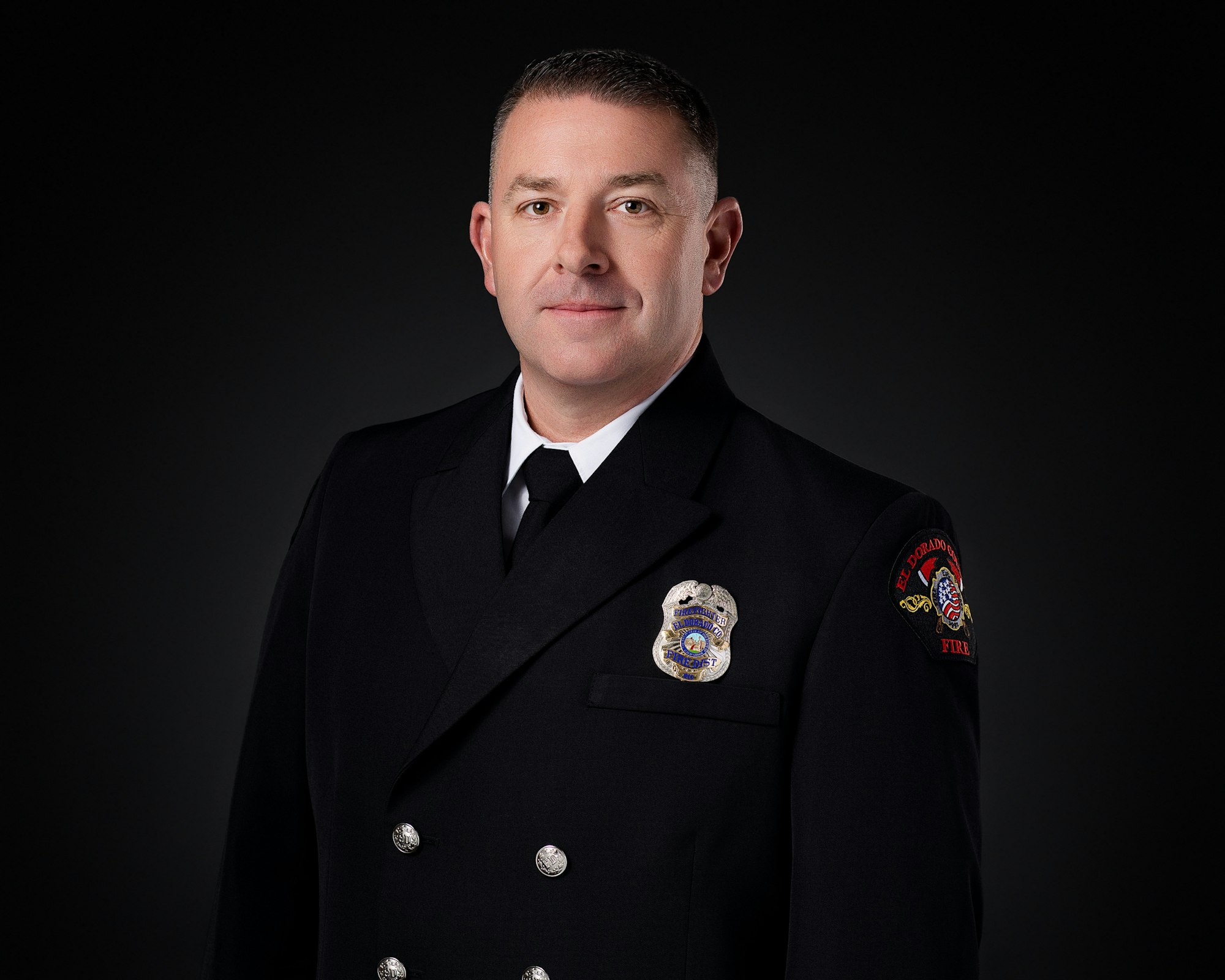The image features a man in a formal dark uniform with a badge, suggesting he is a firefighter or emergency responder.