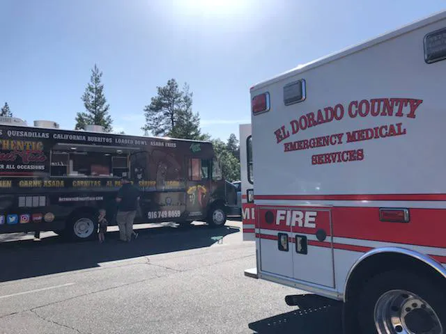 A food truck offers California-style cuisine, while an emergency medical services vehicle is parked nearby.