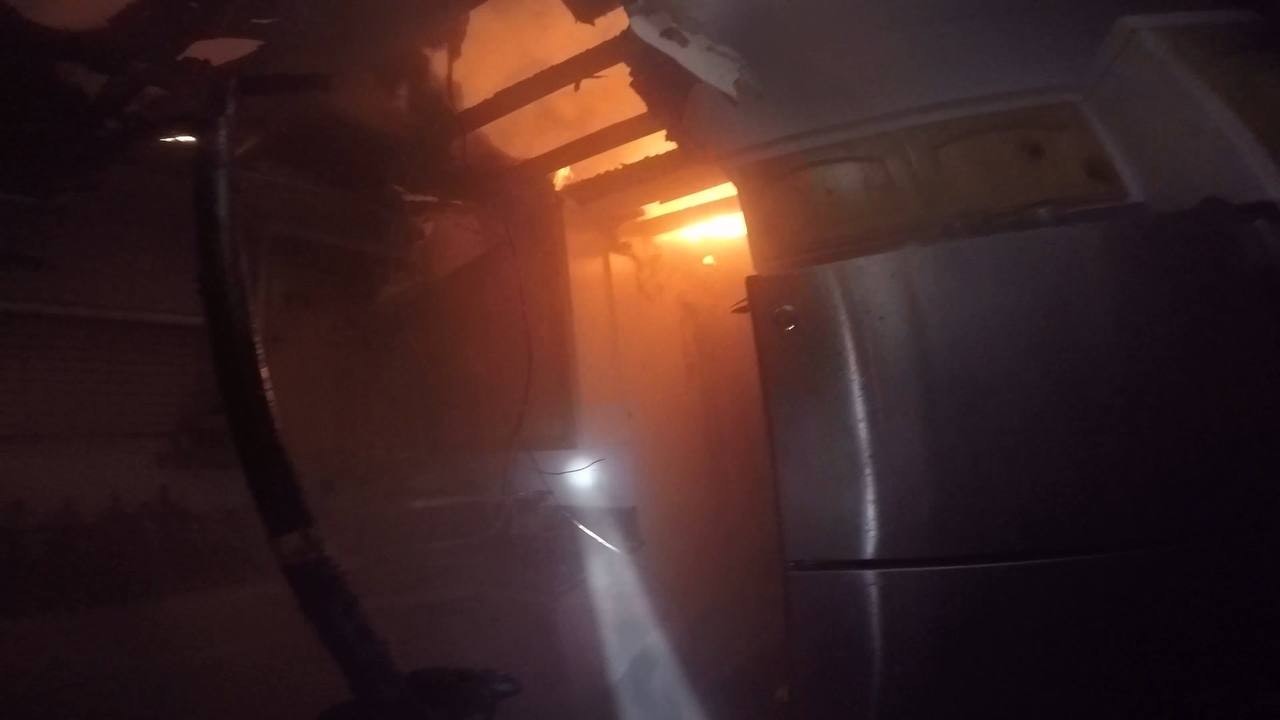 contains refrigerator, dark hallway, fire coming from ceiling
