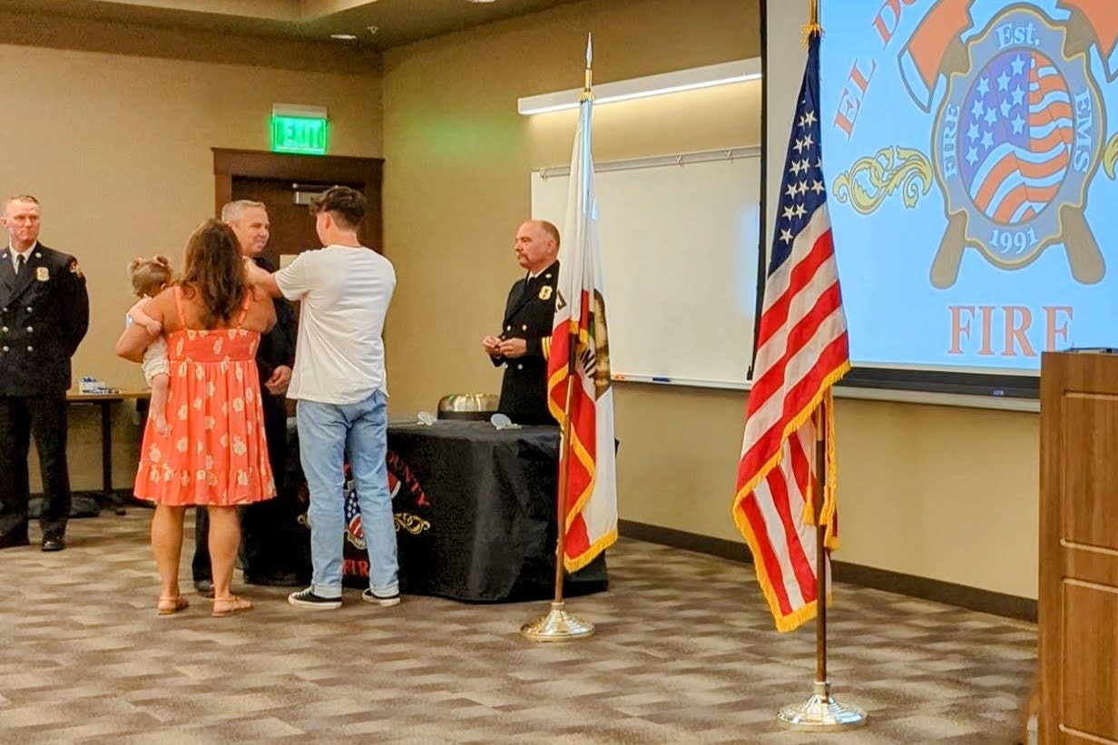 May contain: person, human, clothing, apparel, pants, flag, symbol, and furniture