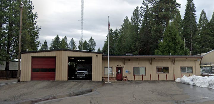 contains fire station, trees, flag pole, ambulance, snow