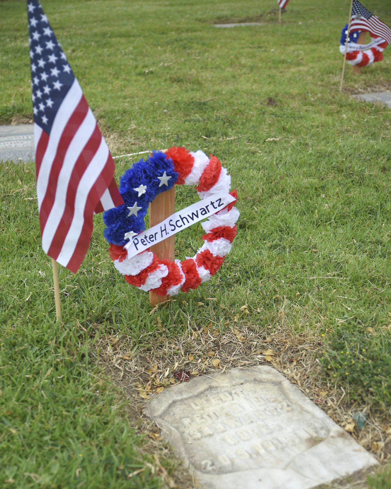 May contain: flag, grass, plant, tomb, and gravestone