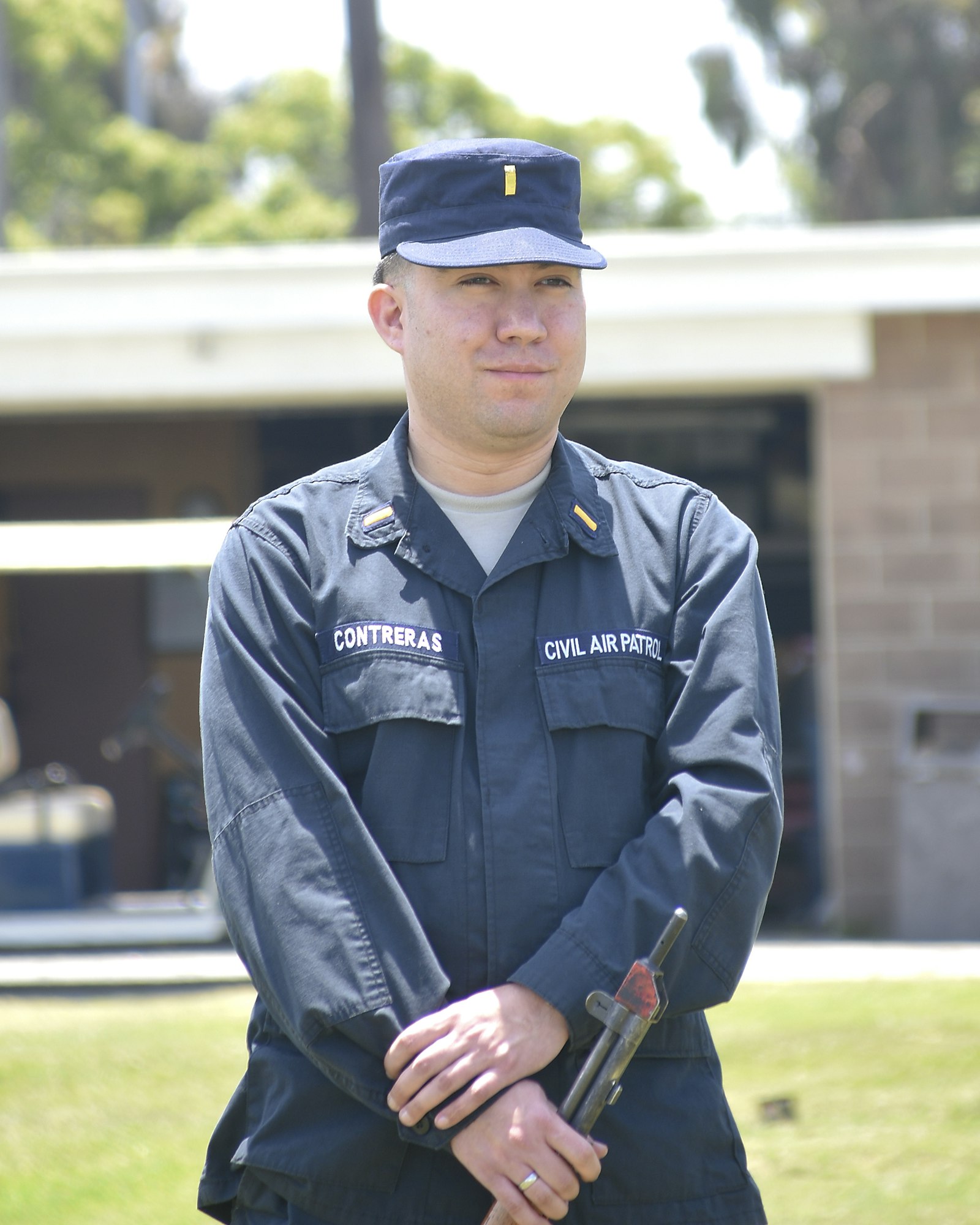 A person in a Civil Air Patrol uniform holding an object, standing outdoors.