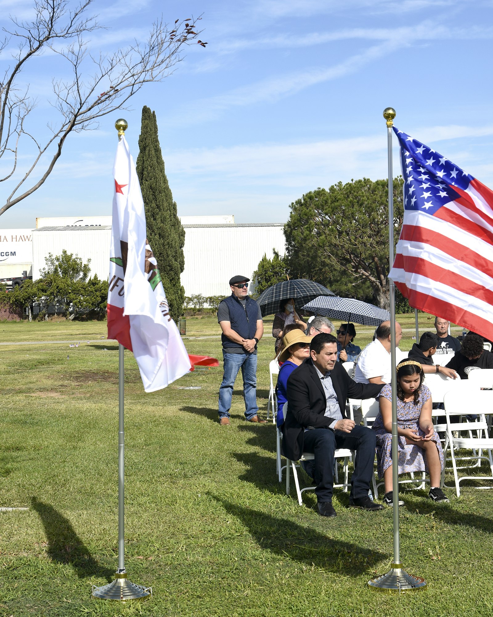 May contain: flag, grass, plant, person, shoe, footwear, clothing, man, adult, male, hat, wristwatch, people, and lawn