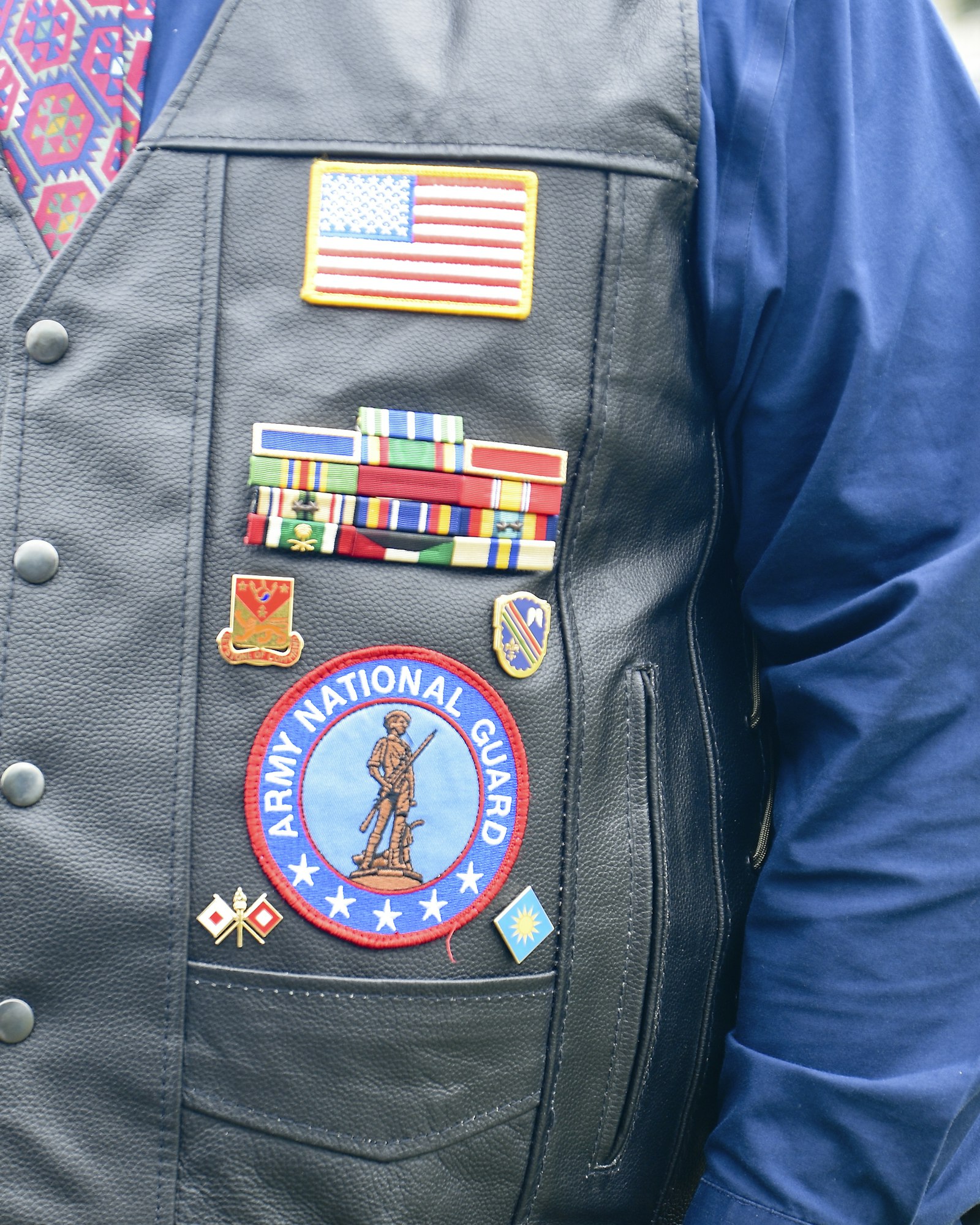 May contain: badge, logo, symbol, clothing, vest, coat, jacket, and person