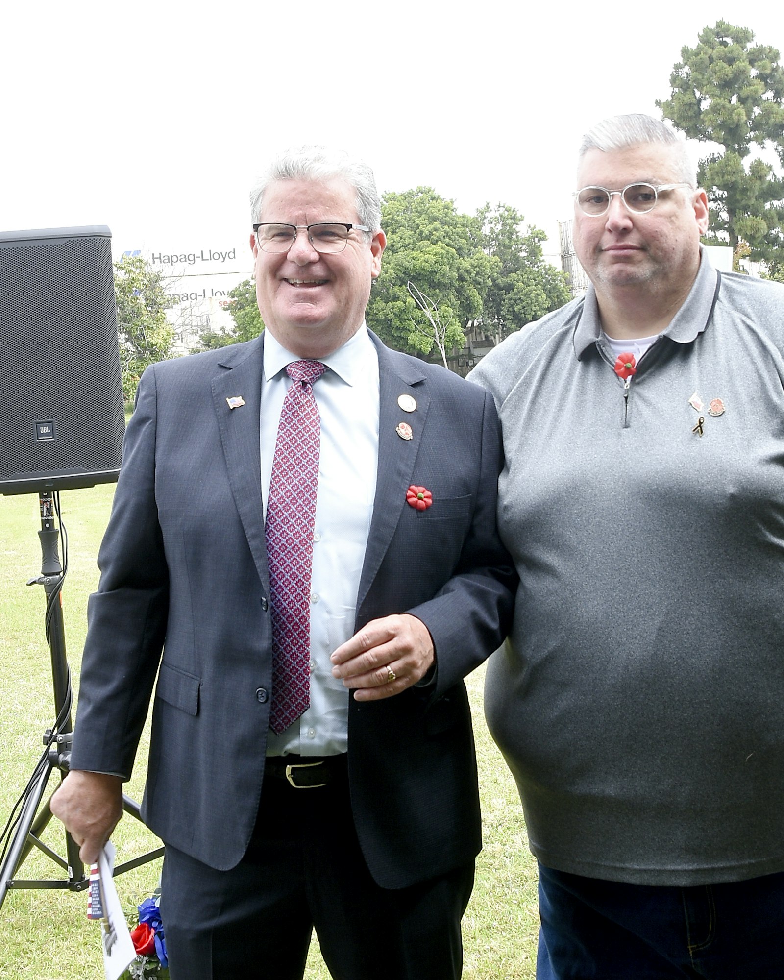 Two men smiling for the camera at an outdoor event.